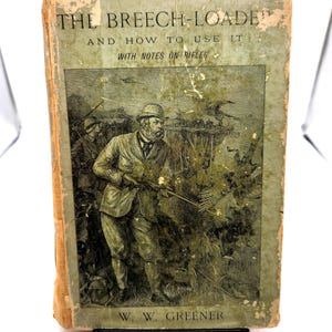 May include: Antique book titled "THE BREECH-LOADER AND HOW TO USE IT WITH NOTES ON RIFLES" by W. W. Greener. The cover features a green and tan illustration of a man in a suit holding a rifle, with other figures in the background. The book has a worn, aged appearance.