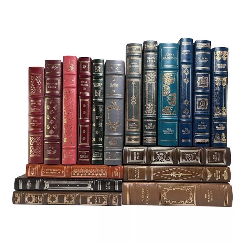 May include: A collection of antique books with leather-bound covers in various colors, including burgundy, pink, green, and blue. The books are arranged in two rows, with gold lettering and decorative details on the spines. The books are from The Franklin Library.