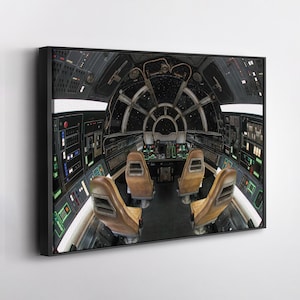 May include: A framed canvas print showing the interior of a spaceship cockpit. The image features a detailed control panel, brown seats, and a view of space through the front window. The artwork is framed in black.