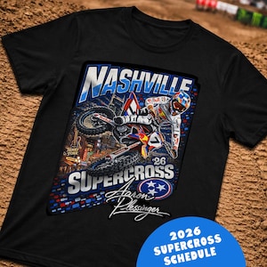 May include: Black t-shirt featuring a colorful graphic of a motocross racer in action, with the words "Nashville Supercross" and "Aaron Plessinger". A blue circle at the bottom reads "2026 Supercross Schedule".