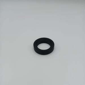 May include: A black, circular rubber gasket with a hole in the center. The gasket is made of a solid, matte material and is designed to create a seal. The object is set against a plain white background.