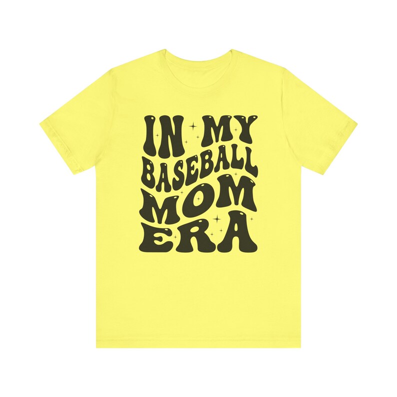 May include: Yellow t-shirt with black text that reads "In My Baseball Mom Era" in a retro font.