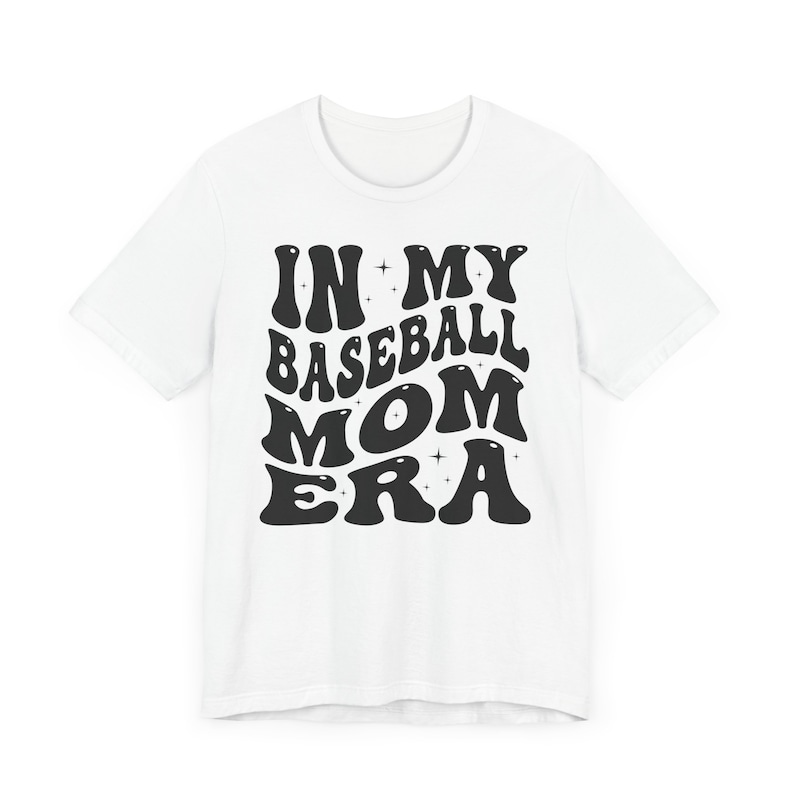 May include: White t-shirt with black text that reads "In My Baseball Mom Era" in a retro font.