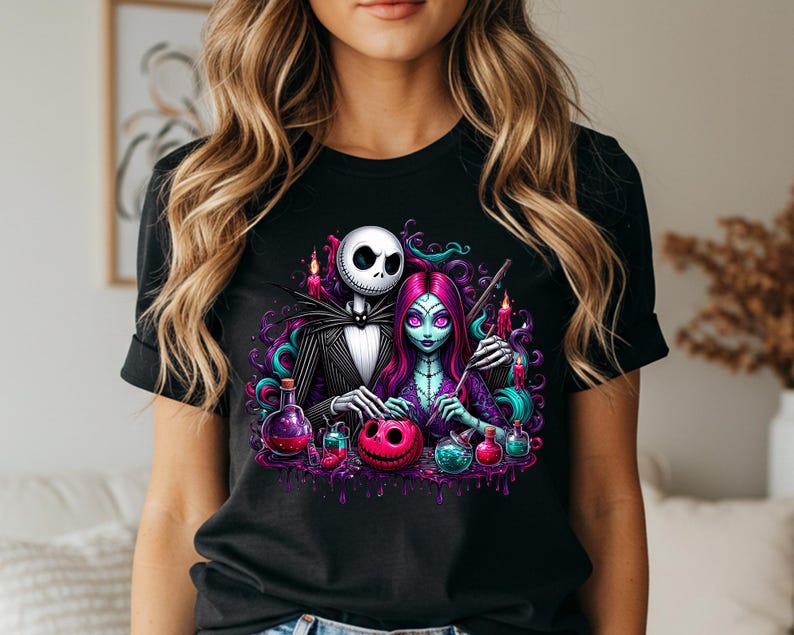 Pode incluir: Camiseta preta com uma ilustra&ccedil;&atilde;o colorida de Jack Skellington e Sally de O Estranho Mundo de Jack. O design inclui frascos de po&ccedil;&otilde;es, velas e uma ab&oacute;bora rosa. A obra de arte tem um tema de Halloween.