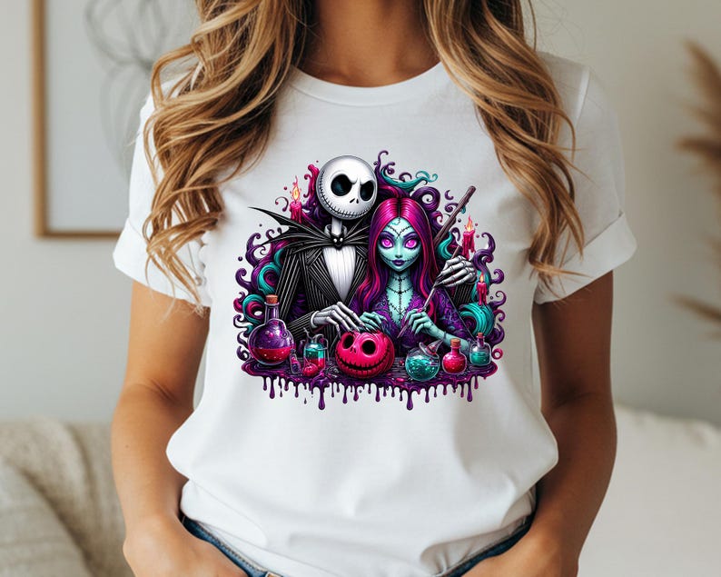 Pode incluir: Camiseta branca com um gr&aacute;fico colorido de Jack Skellington e Sally de The Nightmare Before Christmas. O design inclui frascos de po&ccedil;&otilde;es, uma ab&oacute;bora esculpida e detalhes em espiral roxo e turquesa. Os personagens s&atilde;o retratados em um estilo de desenho animado assustador.