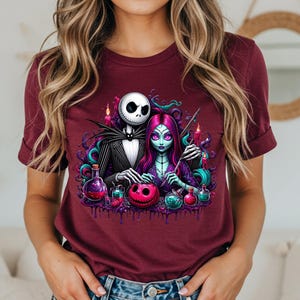 Pode incluir: Camiseta bord&ocirc; com um gr&aacute;fico colorido de Jack Skellington e Sally de The Nightmare Before Christmas. O design inclui frascos de po&ccedil;&otilde;es, uma ab&oacute;bora rosa e uma est&eacute;tica g&oacute;tica.
