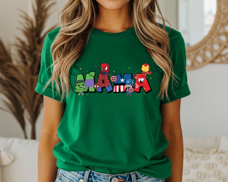 Puede incluir: Una camiseta verde con la palabra "MARVEL" en letras de dibujos animados. Cada letra est&aacute; dise&ntilde;ada con un personaje diferente de Marvel, incluyendo Hulk, Spider-Man, Capit&aacute;n Am&eacute;rica e Iron Man. La camiseta tiene mangas enrolladas.