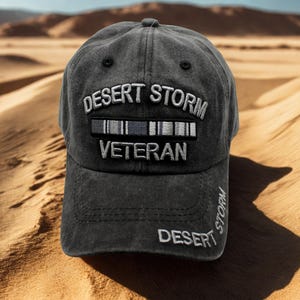 Puede incluir: Gorra de béisbol gris oscuro con las palabras "DESERT STORM VETERAN" bordadas en blanco. La gorra presenta un aspecto desgastado y una visera curva. La palabra "DESERT" también está bordada en el lateral.