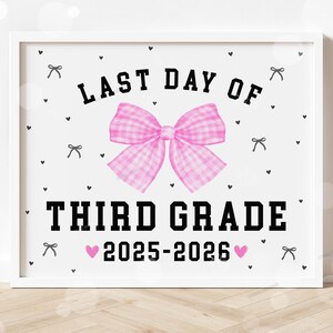 Pode incluir: Impressão emoldurada com o texto "LAST DAY OF THIRD GRADE 2025-2026" em preto. Um laço rosa xadrez está centralizado acima do texto. Pequenos laços e corações pretos estão espalhados.