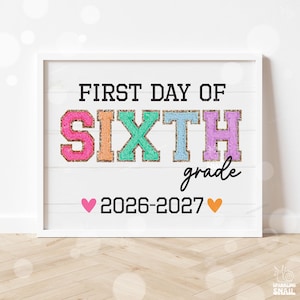May include: A white sign with the black text FIRST DAY OF and grade. The word SIXTH is displayed in large, colorful, textured varsity-style letters in pink, orange, green, blue, and purple. The text 2026-2027 is centered with a pink and orange heart.