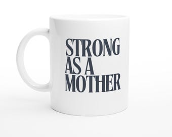May include: White ceramic coffee mug with the text "STRONG AS A MOTHER" in dark blue lettering.