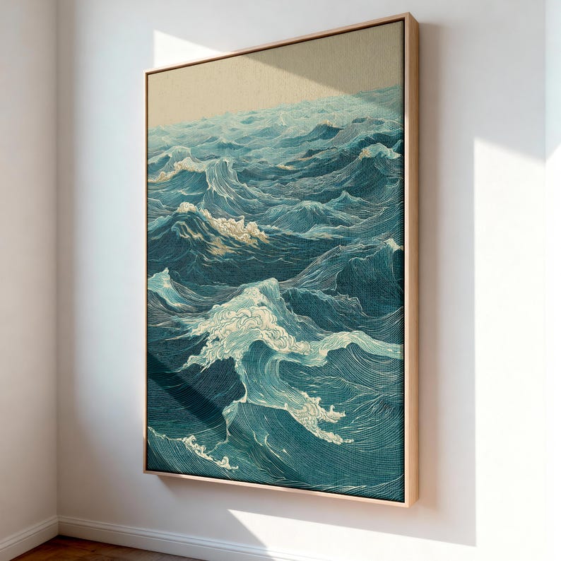 May include: A framed artwork depicting a stylized ocean scene. The artwork features detailed linework in shades of blue and white, creating a textured appearance of waves. The frame is a light wood color, adding a natural touch to the piece.