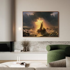 May include: A rectangular framed wall art print depicting a sailboat navigating turbulent, choppy ocean waves under a dramatic, stormy sky with golden sunlight breaking through the dark clouds. A small figure stands on a rocky shore in the foreground.