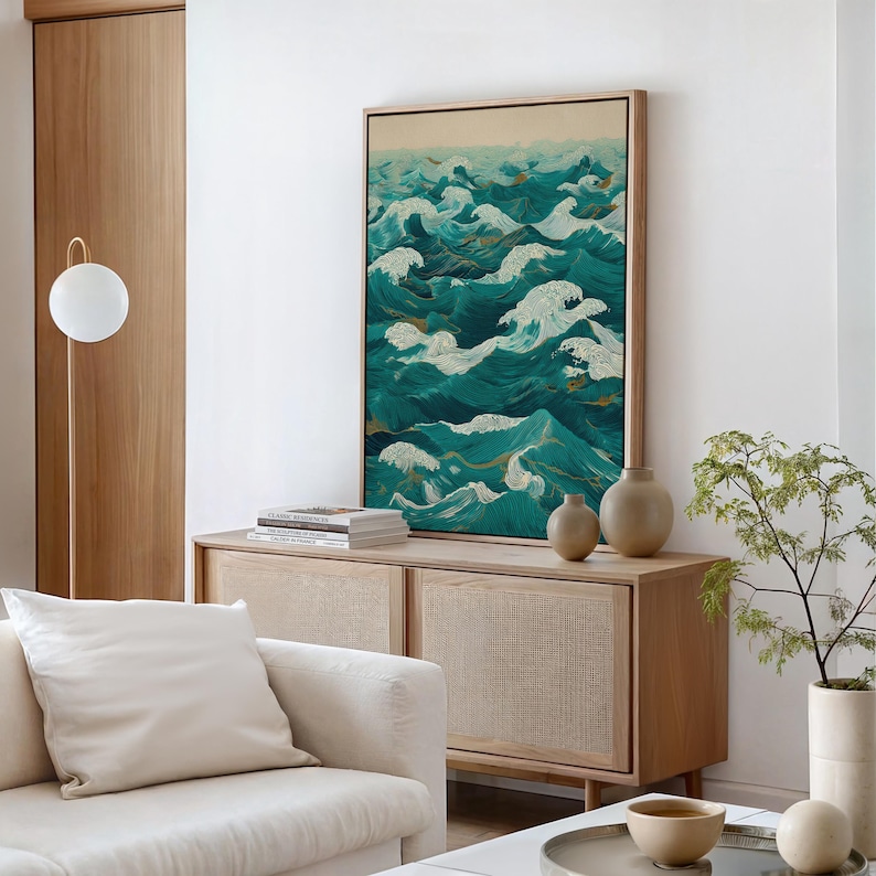 Pu&ograve; includere: Un'opera d'arte incorniciata raffigurante onde oceaniche stilizzate nei toni del verde acqua e bianco. L'opera &egrave; esposta sopra un mobile in legno con due piccoli vasi. Un divano bianco e una moderna lampada da terra sono visibili.