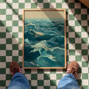 May include: A framed art print depicting a stylized ocean scene with teal and white waves. The artwork has a vintage aesthetic, with detailed linework and a muted color palette. The frame is a light wood color.
