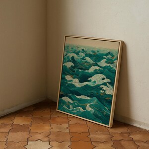 Pu&ograve; includere: Una stampa artistica incorniciata raffigurante onde oceaniche nei toni del verde acqua e bianco. L'opera d'arte &egrave; in una cornice di legno chiaro e poggia contro un muro bianco. Il pavimento &egrave; piastrellato con un motivo geometrico.