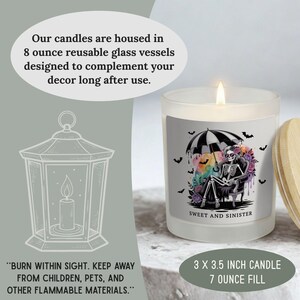 May include: A lit, frosted glass candle with a wooden lid. The candle features a label with a skeleton under an umbrella, surrounded by bats and flowers. The text "Sweet and Sinister" is visible.