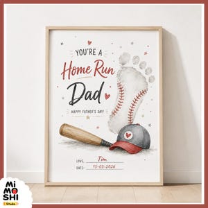 以下が含まれることがあります： 野球をテーマにしたフレームプリント。アートワークには「You're a Home Run Dad」と「Happy Father's Day!」の文字、野球のバット、野球帽、足跡が描かれています。「Tim」という名前と「15-05-2026」という日付でパーソナライズされています。