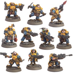 May include: A group of miniature figurines of fantasy soldiers in yellow armour and blue uniforms. Each figure is posed with a weapon, such as a rifle, knife, or grenade. The figures are on a grey base.