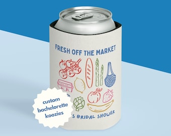 May include: A white koozie with a silver can inside. The koozie has the text "FRESH OFF THE MARKET" and a colorful illustration of produce. A white starburst sticker says "custom bachelorette koozies".
