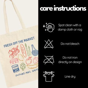 May include: Cream-colored tote bag with a colorful illustration of produce and the text "FRESH OFF THE MARKET" and "FUTURE MRS. SMITH." Care instructions are listed on a black background. The bag features a variety of fruits and vegetables.