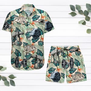 May include: A tropical print button-up shirt and matching shorts featuring Star Wars characters and spaceships. The shirt has short sleeves and a button-up front. The shorts have an elastic waistband and a drawstring.