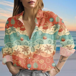 May include: A button-down shirt with a tropical beach-themed pattern. The shirt features illustrations of palm trees, pineapples, beach balls, and umbrellas in shades of red, orange, yellow, and blue. The long-sleeved shirt has a collared neckline.