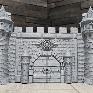 May include: A gray 3D printed castle wall with towers and a large gate. The gate has a decorative design and a symbol above it. The castle is made of brick and has a medieval style.
