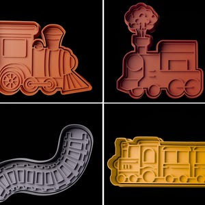 May include: Four cookie cutters in the shape of trains and train tracks. The train cutters are in shades of orange and yellow. One train cutter has a smoke cloud. The train track cutter is grey.