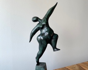 バランスをとる女性の像：緑青ブロンズ彫刻、重力に逆らう気まぐれな