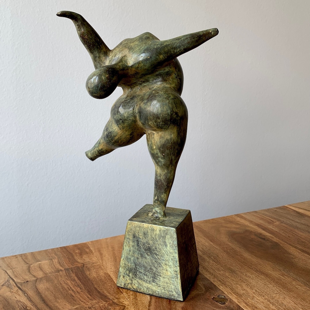 バランスをとる女性の像：緑青ブロンズ彫刻、重力に逆らう気まぐれな