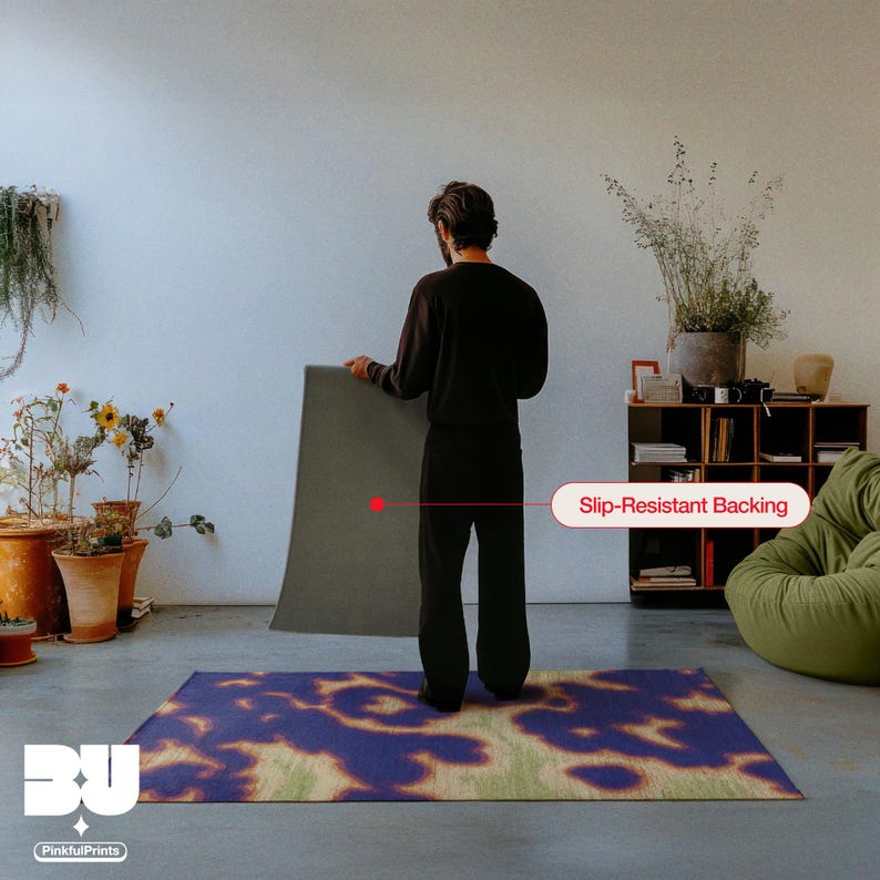Person holding and showing the back of the rug with a slip-resistant backing showcase in a living room, highlighting a demonstration of the vibrant purple, orange, yellow and green hues animal print with faux textile and weaving hand painted texture, a printed area rug for the maximalist eclectic home.
