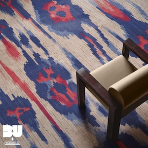 May include: A beige and brown patterned rug with red and blue accents. A wooden chair with a beige cushion sits on the rug.