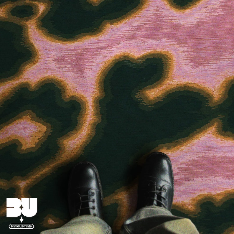 Man standing on an eclectic home decor, the dopamine colorful pink psychedelic area rug, with abstract cowhide animal print with faux textile texture in dark green, pink and yellow hues printed rug 8x10.