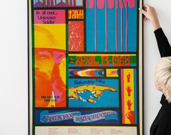 May include: A vintage concert poster advertising The Doors performing at the Santa Rosa Fairgrounds on April 13, 1968. The poster features a psychedelic design with a bright yellow, orange, and red image of a man's face, a blue background with the word "Doors" in pink and white letters, and a map of the Santa Rosa area.