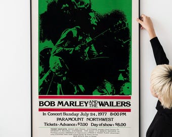 May include: A vintage concert poster for Bob Marley and the Wailers, featuring a black and white silhouette of Bob Marley playing a guitar against a green background. The poster advertises a concert on July 24, 1977 at the Paramount Northwest in Seattle, Washington. The text on the poster reads "Bob Marley and the Wailers, In Concert Sunday July 24, 1977 8:00 PM, Paramount Northwest, Tickets-Advance: $7.00 Day of show: $8.00, A Stormy Weather Production, Printed in USA."