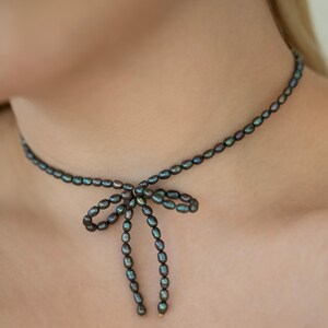 Elegant black pearl choker necklace worn by a model, showcasing its timeless and sophisticated design. Perfect for formal occasions or adding a touch of class to everyday outfits.