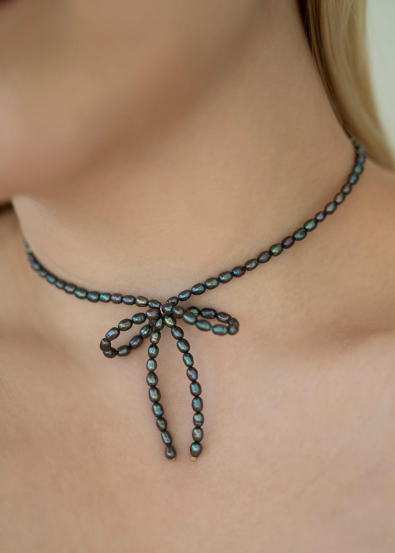 Elegant black pearl choker necklace worn by a model, showcasing its timeless and sophisticated design. Perfect for formal occasions or adding a touch of class to everyday outfits.