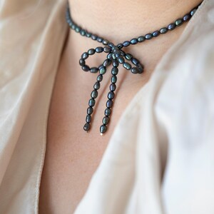 Elegant black pearl choker necklace worn by a model, showcasing its timeless and sophisticated design. Perfect for formal occasions or adding a touch of class to everyday outfits.