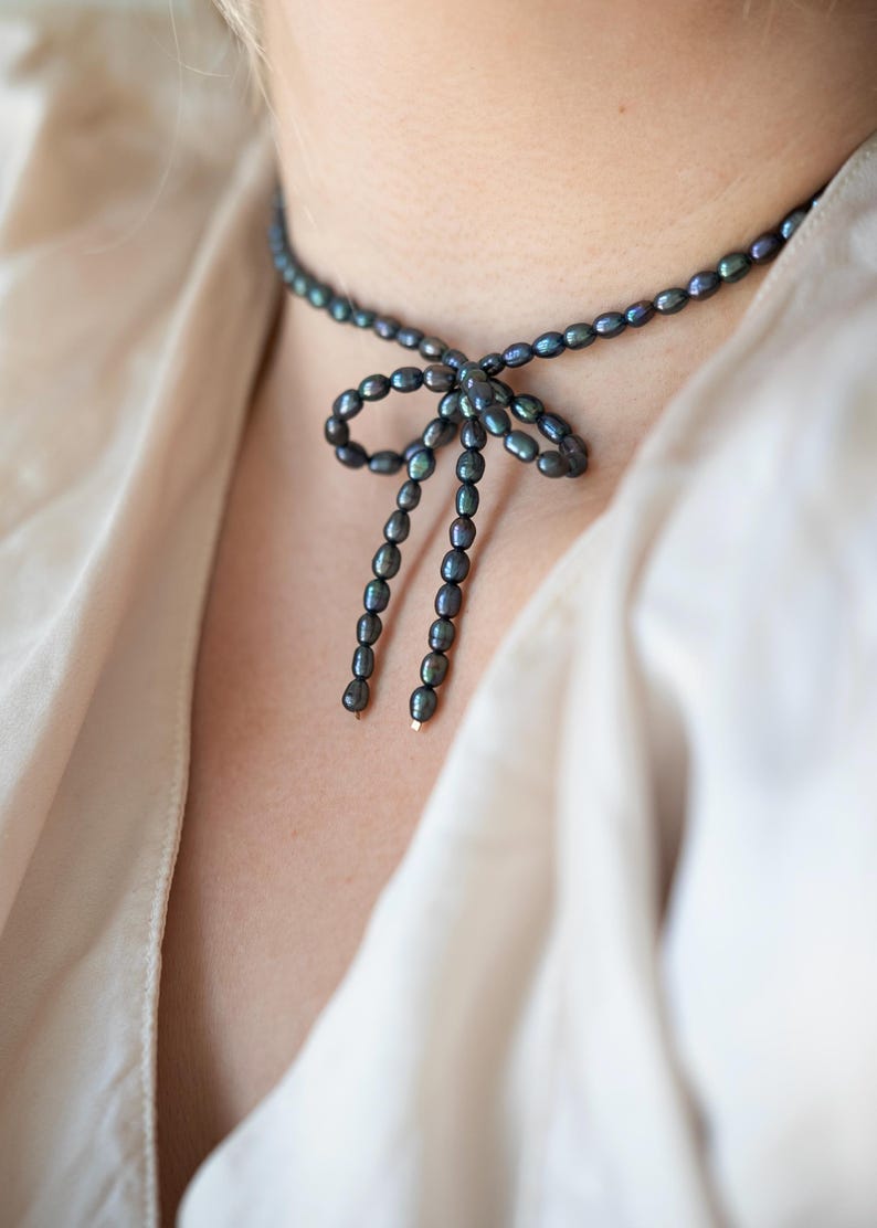 Elegant black pearl choker necklace worn by a model, showcasing its timeless and sophisticated design. Perfect for formal occasions or adding a touch of class to everyday outfits.