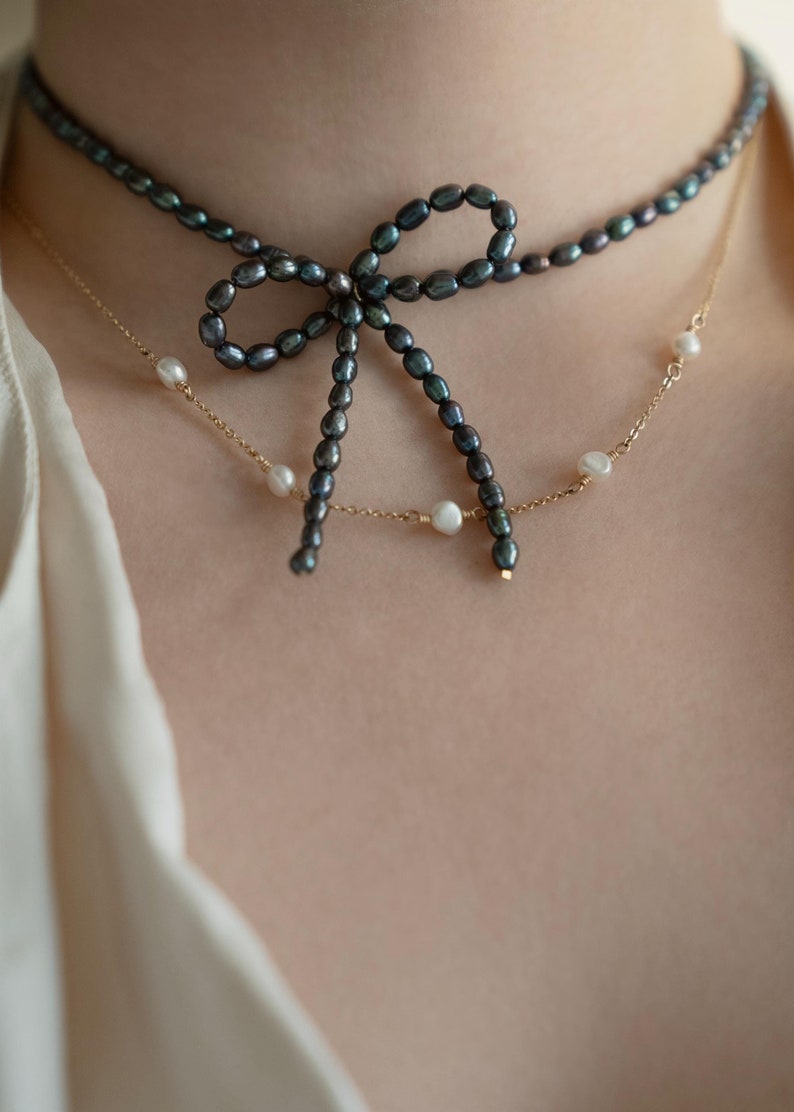 Elegant black pearl choker necklace worn by a model, showcasing its timeless and sophisticated design. Perfect for formal occasions or adding a touch of class to everyday outfits.