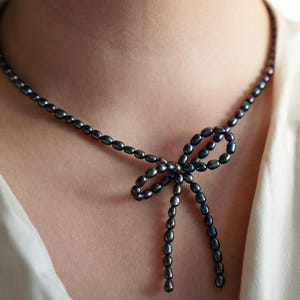 Elegant black pearl choker necklace worn by a model, showcasing its timeless and sophisticated design. Perfect for formal occasions or adding a touch of class to everyday outfits.