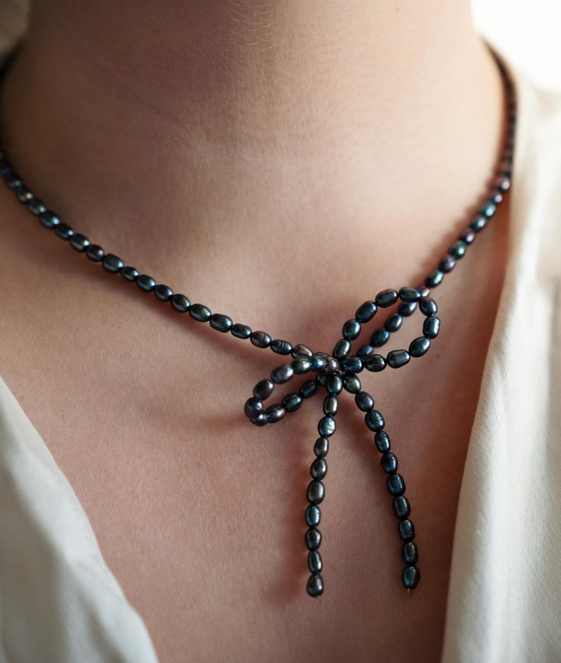 Elegant black pearl choker necklace worn by a model, showcasing its timeless and sophisticated design. Perfect for formal occasions or adding a touch of class to everyday outfits.