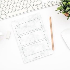 May include: A white marble notepad with three blank sections for writing. The sections are labelled "To-do", "Doing", and "Done". The notepad has a black border and the text "GROW AND FLOW STUDIO" at the bottom.