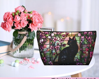 Bolsa de maquillaje con diseño de gato negro y flores rosas.
