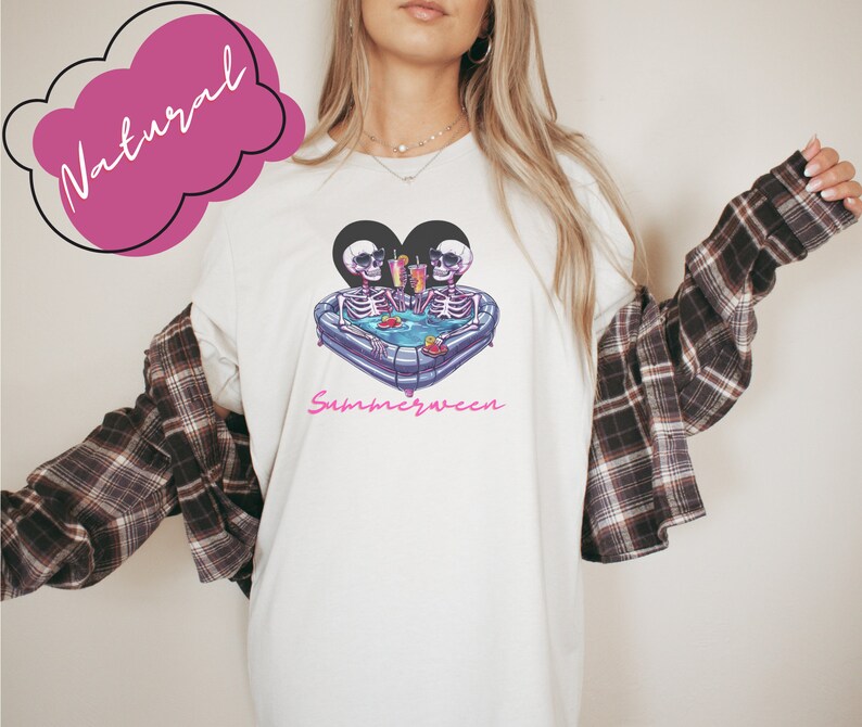 May include: White t-shirt with a graphic of two skeletons in a heart-shaped inflatable pool with drinks. The text "Summerween" is printed below the graphic.