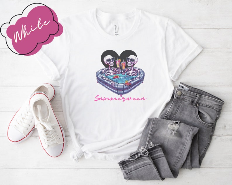 May include: White t-shirt with a graphic of two skeletons in a heart-shaped inflatable pool with the text "Summerween" underneath.