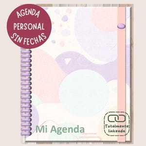 Op de afbeelding: Een roze, paarse en blauwe planner met abstract ontwerp en een spiraalbinding. De omslag heeft de tekst "Agenda Personal Sin Fechas" en "Mi Agenda" met een groen kettingsymbool met de tekst "Totalmente linkeada".