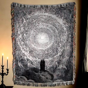 May include: A monochrome woven tapestry depicting a swirling celestial scene with figures and a bright light source. The tapestry has a fringed edge with red and tan details, and is displayed on a beige wall.