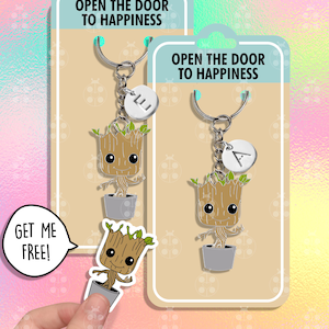 Puede incluir: Dos llaveros con un personaje de dibujos animados que se parece a Groot de Guardianes de la Galaxia. El personaje es verde y marrón y sostiene una maceta pequeña. Los llaveros tienen una cadena plateada y un dije plateado con una letra. Los llaveros se muestran en una tarjeta blanca con el texto "Abre la puerta a la felicidad".